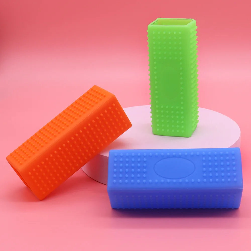 Three colorful foam rollers (orange, green, blue) on a pink background