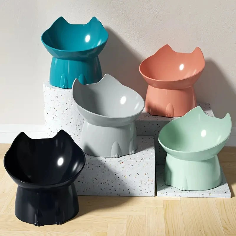 Set of colorful cat-shaped bowls on a wooden surface with a light background